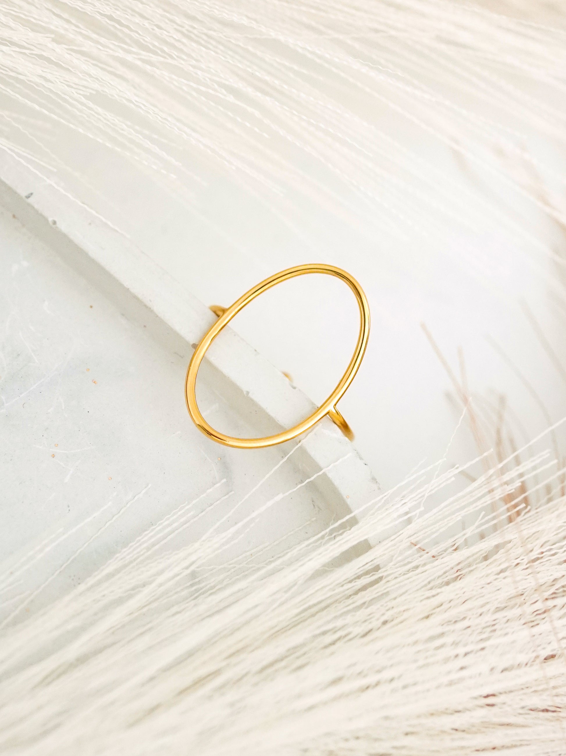 Gold-plated ring on a textured white surface