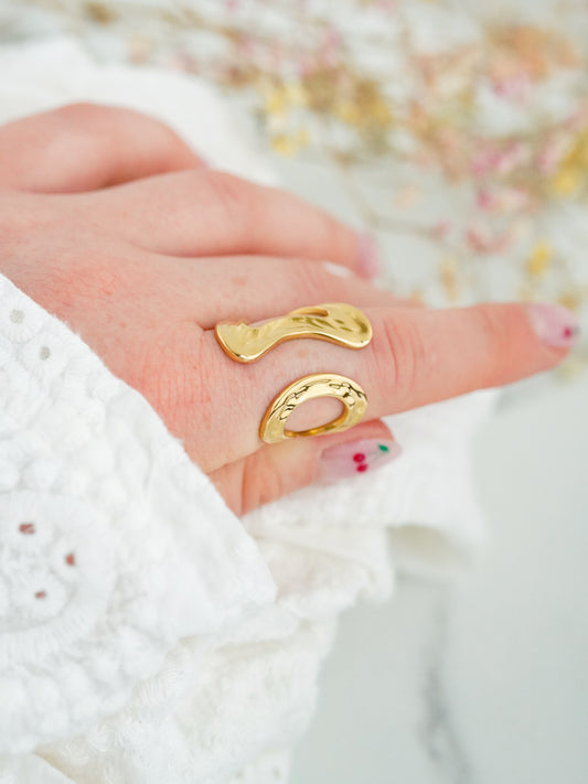 Gold-plated ring on a finger with a blurred background