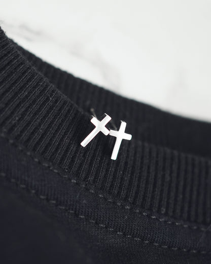 Black sweater with a white embroidered symbol on a white background