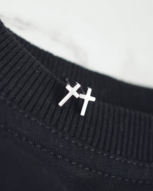 Black sweater with a white embroidered symbol on a white background