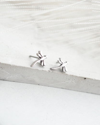Silver earrings on a light wooden surface