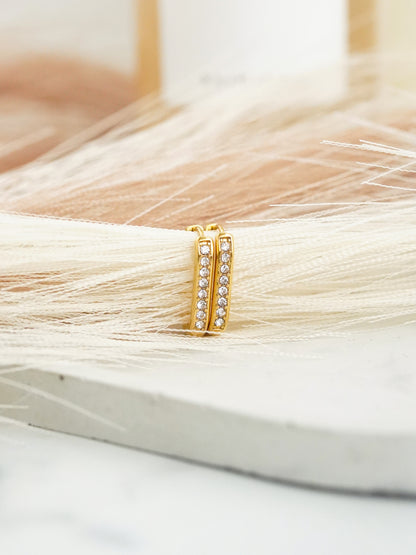 Gold hoop earrings with embedded stones on a white background