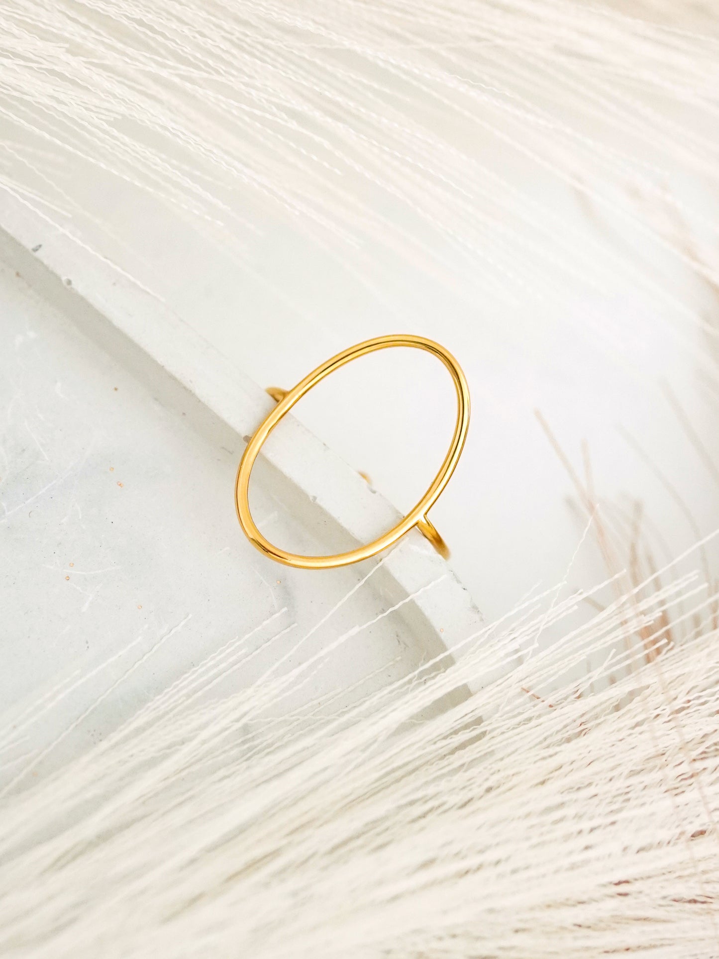 Gold-plated ring on a textured white surface