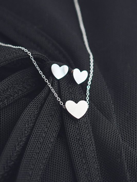 Necklace with heart-shaped pendants on a black fabric background